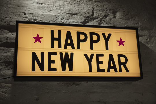 Close-up of Happy New Year signboard against gray wall