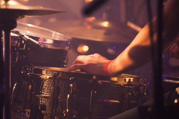 Drummer plays on drum set, toned