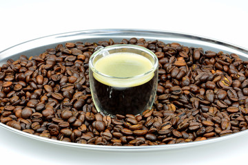 Espresso mit Kaffeebohnen am Serviertablett mit weißem Hintergrund