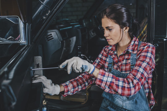 Female mechanic repairing car at workshop