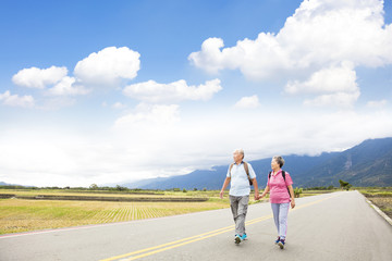 Obraz premium senior couple hiking on the country road