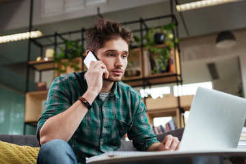 Man talking at phone on sofa