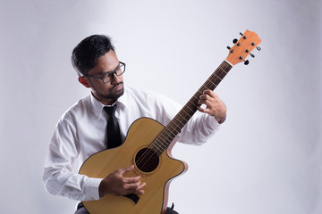 Studio portrait of senior man playing guitar.