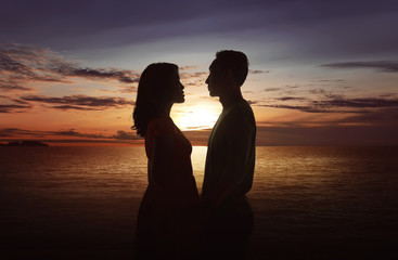Silhouette couple looking each other on the beach