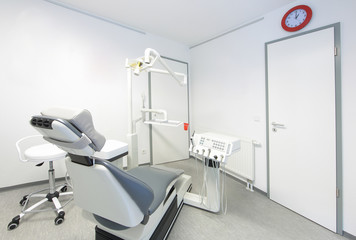Zahnarztstuhl in moderner Zahnarztpraxis mit weissen Wänden