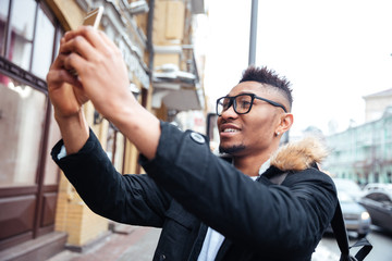 African happy man make a selfie outdoors.