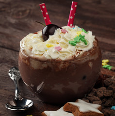 Hot chocolate cocoa with whipped cream on vintage wooden background, selective focus 