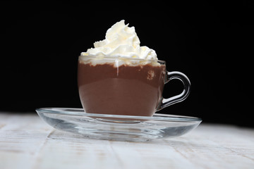 Hot chocolate cocoa with whipped cream on vintage wooden background, selective focus 