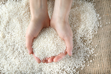 Female hands full of white rice closeup