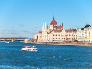 Obraz premium Daytime view of historical building of Hungarian Parliament, aka Orszaghaz, with typical symmetrical architecture and central dome on Danube River embankment in Budapest, Hungary, Europe. It is