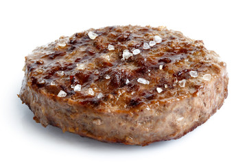 Single grilled hamburger patty with salt isolated on white.