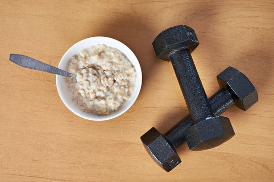 Porridge and dumbbells symbol of sports lifestyle