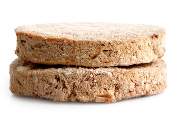 Two frozen hamburger patties isolated on white.