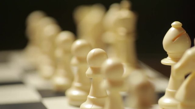Panning shot of a chess board, with focus shifting on the white pieces.