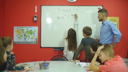 schoolgirl writes on the blackboard the date - Powered by Adobe