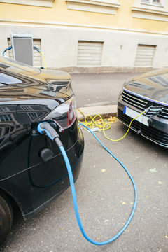 Electric car charging. City street.
