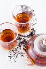 cup of tea and a teapot on a wooden white background
