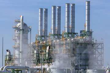 Refinery tower in petrochemical industrial plant with cloudy sky
