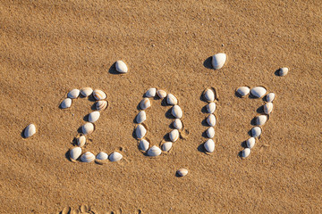 Fototapeta na wymiar Happy New Year 2017 on golden sand of the beach