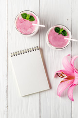 Berry smoothie with yogurt and notepad