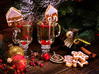 Two glasses of grog, decoration Christmas cookies in shape of houses. Christmas balls and Christmas...