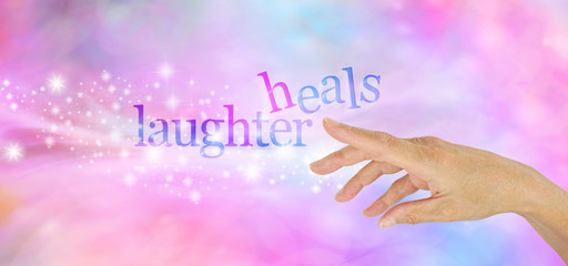 Laughter is the Best Medicine  - Female hand pointing at a sparkly glittering 'LAUGHTER HEALS' on a pink and blue bokeh background