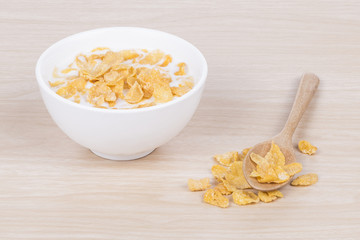 Cornflakes with milk in the white bowl.

