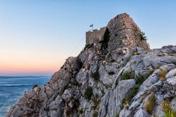 Fototapeta premium Old fortress on the top of the rocky Dinara mountain over Adriatic sea, Omis, Croatia