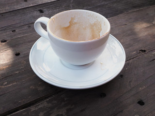Empty coffee cup after drinking on wooden background.