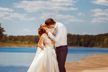 Beautiful wedding couple is kissing at beach background