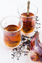 cup of tea, tea leaves and tea pot on a white background