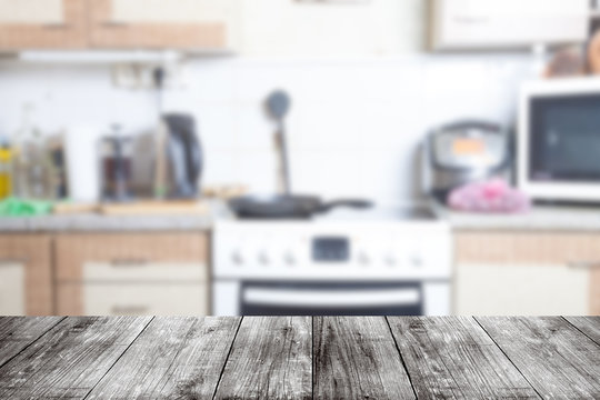View from dark wooden table on a blurred kitchen interior