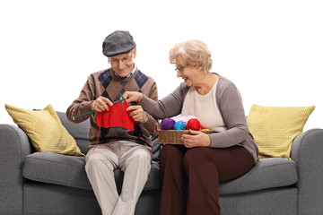 Obraz premium Elderly woman teaching an elderly man how to knit