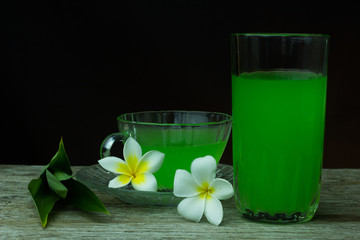 Glass of cold Pandan juice - healthy food against wood,.With pan