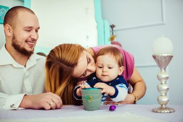 Mother and father hugging and kissing son in home interior