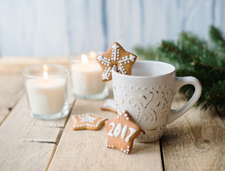 Cup of hot chocolate with gingerbread and candle.