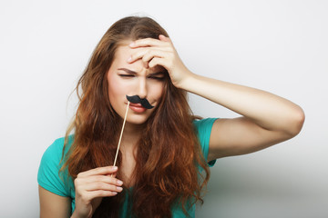 Young happy woman with  fake mustaches