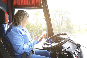 Female driver using tablet in bus