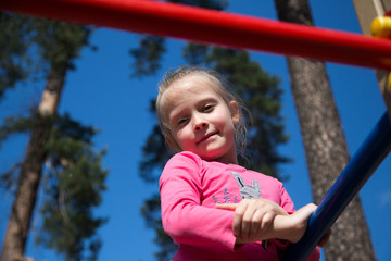 Obraz premium Little girl on a playground. Child playing outdoors in summer. 