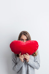 Woman holding heart pillow