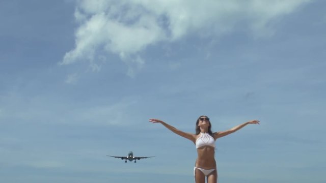 Girl With Raised Hands With Landing Airplane 