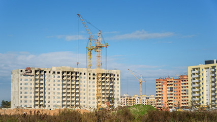 Fototapeta na wymiar construction of apartment buildings and crane on blue sky background