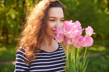 Naklejka premium Young cute woman smelling pink flowers