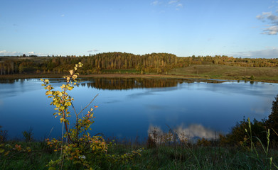 blue sky reflected in lake at forest background
