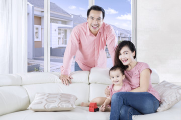 Fototapeta premium Cute daughter plays toy with parents