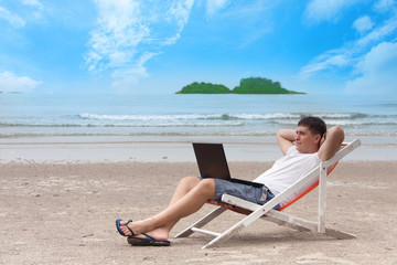 Work of dream in open air. Freelancer man sitting in deck chair on sea beach. Freelance and remote work