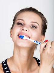Close-up of a young woman is brushing her teeth. Dental health care concept.