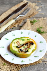 Home stuffed omelet on a plate, fork, knife on old wooden table. Tasty omelet with fried mushrooms in a bell pepper. Healthy egg idea for breakfast. Rustic style. Closeup