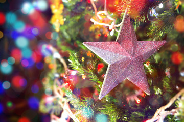 Closeup of stars hanging from a decorated Christmas tree.
