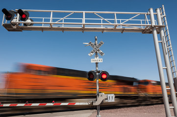 Zooming train engine speeding past railroad crossing